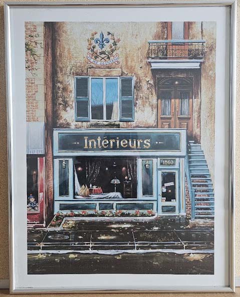 Framed artwork of a store front with 'Interieurs' sign on a brick building.