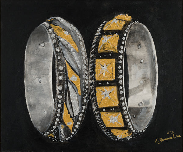 Two intricately designed rings with gold and silver accents on a black background