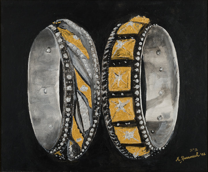 Two intricately designed rings with gold and silver accents on a black background