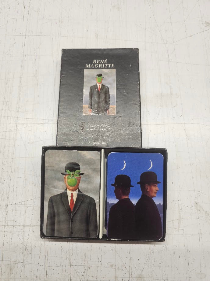 Collection of Rene Magritte art books and cards on a textured surface