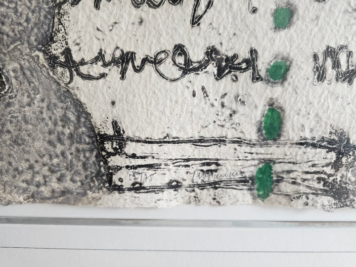 Abstract artwork with black and green elements on a textured surface