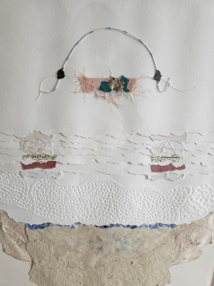 Textile art piece with embroidered elements on a textured white background