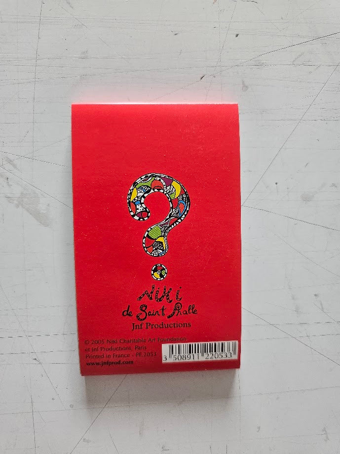 Red card with a colorful question mark design on a gray surface