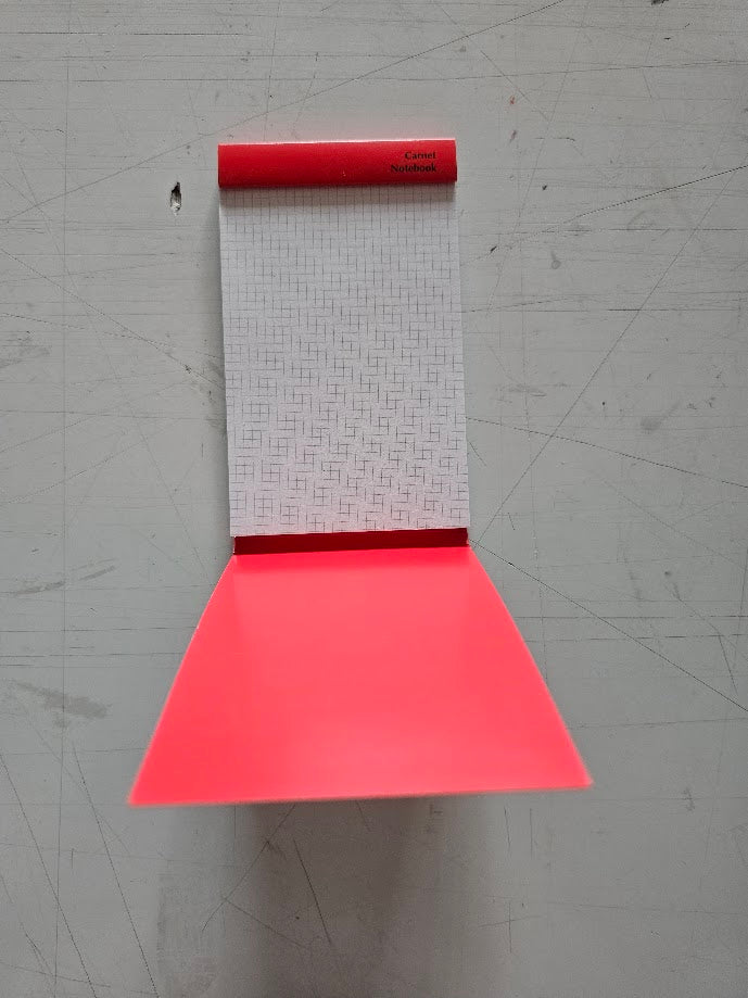 Red roll of wallpaper with a textured pattern on a gray surface