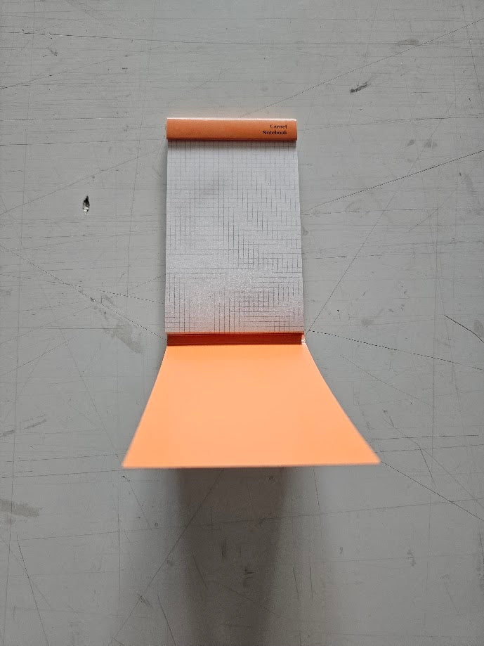 Orange yoga mat with grid pattern on a gray floor