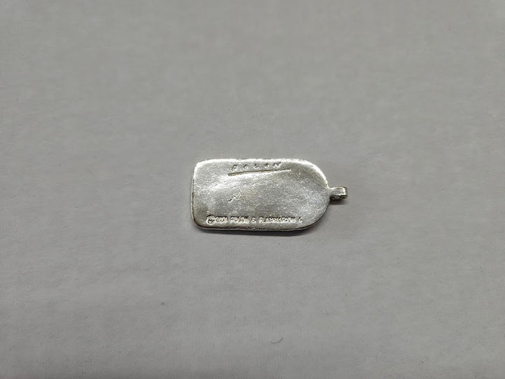 Silver pendant on a gray background